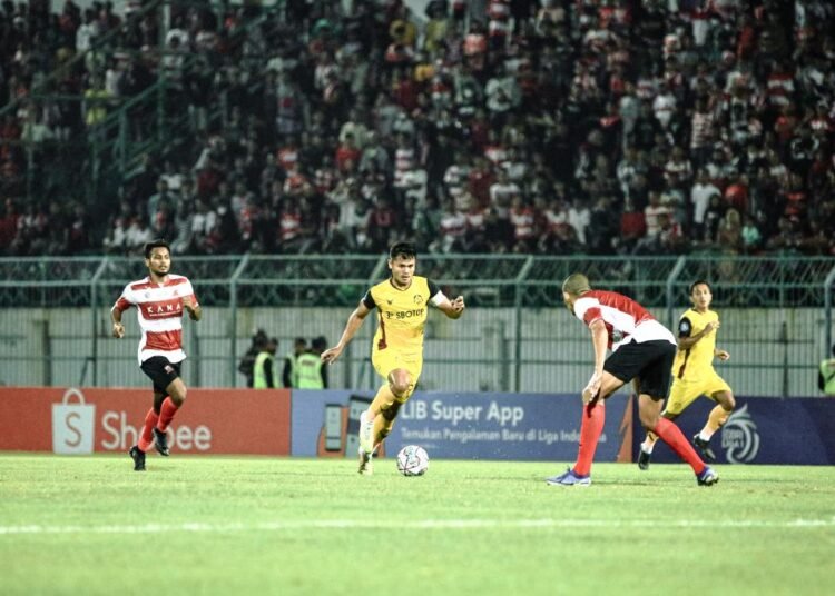 Striker Persikabo 1973 Dimas Drajad saat mencoba melewati pemain Madura United