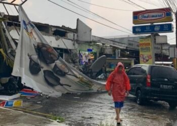 Akibat Hujan Disertai Angin Kencang, Sebuah Baliho Menimpa Atap Minimarket Di Cibinong