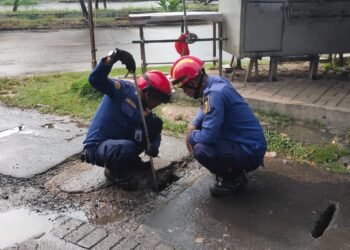 Tim Rescue Damkar Kabupaten Bogor saat melakukan pertolongan mengambil kunci motor yanh jatuh di saluran air, di Vila Nusa Indah, Gunung Putri, Kabupaten Bogor.