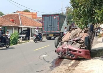 Diduga Sopir Mengantuk Mobil Sedan Tabrak Tiang Rumah Warga Hingga Terbalik