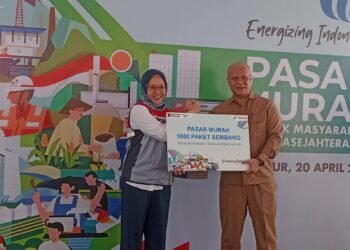 Pasar Murah Pertamina Cianjur 2026, 1.000 Paket Sembako Murah Diserbu Warga   Cianjur24update – Pasar murah Pertamina Cianjur 2026 yang digelar di Kecamatan Gekbrong, Kabupaten Cianjur, diserbu ribuan warga pada Senin, 20 April 2026.   Program ini menyediakan sembako murah bagi masyarakat pra-sejahtera.  PT Pertamina Patra Niaga Regional Jawa Bagian Barat menyalurkan 1.000 paket sembako murah melalui program Tanggung Jawab Sosial dan Lingkungan (TJSL).   Kegiatan pasar murah di Cianjur ini bertujuan membantu meringankan beban ekonomi sekaligus menjaga stabilitas harga bahan pokok.  Senior Supervisor CSR dan SMEPP Pertamina Patra Niaga Regional Jawa Bagian Barat, Dila Amanda Kenniza, mengatakan setiap paket sembako murah Pertamina memiliki nilai sekitar Rp211.000. Namun, masyarakat cukup menebus dengan harga Rp30.000.  “Dalam satu paket berisi beras 5 kilogram, minyak goreng 2 liter, kecap, gula pasir, sarden, dan susu,” ujarnya.  Program pasar murah Pertamina ini tidak hanya digelar di Cianjur.   Kegiatan serupa juga berlangsung di beberapa daerah lain seperti Serang, Jakarta, Indramayu, dan Karawang.  Penyaluran sembako murah di Cianjur dilakukan bekerja sama dengan Dinas Koperasi, UKM, Perdagangan dan Perindustrian (Diskumdagin) serta pihak kecamatan.  Penerima manfaat diprioritaskan bagi masyarakat desil 1 hingga 5 agar bantuan tepat sasaran.  Dana hasil penebusan paket sembako murah tidak masuk ke perusahaan, tetapi disalurkan kembali kepada panti asuhan dan masyarakat yang membutuhkan. Sebagian bantuan juga diberikan kepada warga terdampak kecelakaan mobil tangki.  Kegiatan pasar murah Cianjur ini mendapat respons positif dari warga karena dinilai membantu memenuhi kebutuhan pokok di tengah fluktuasi harga bahan pangan.